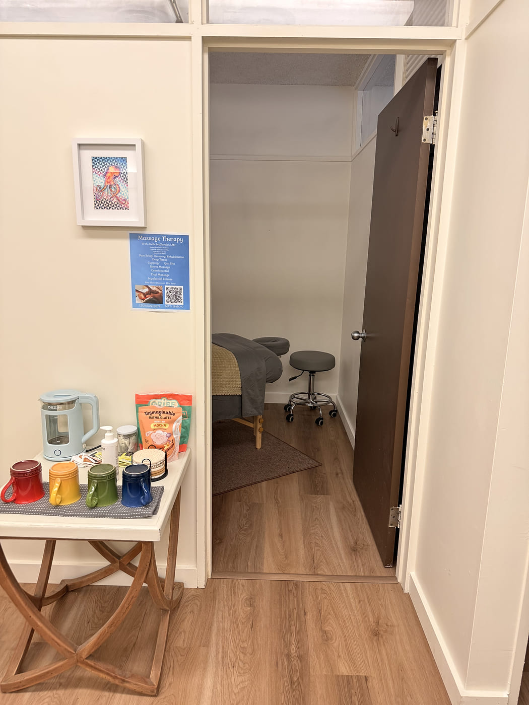 The doorway into Joelle's treatment room, tea table outside, massage table and stool inside
