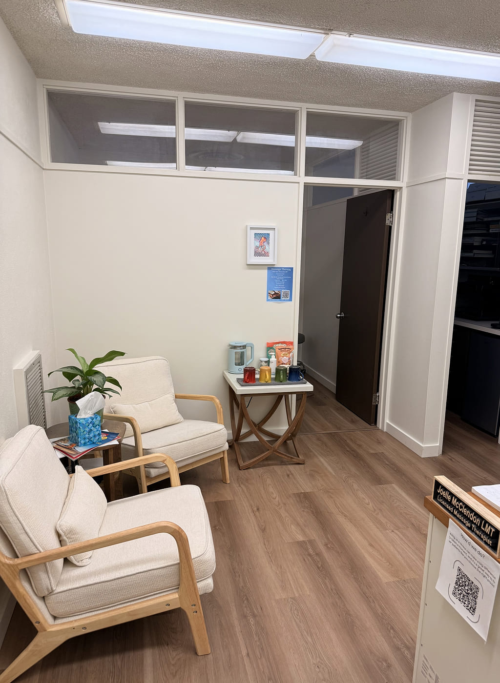Two cream armchairs and a side table in the waiting area